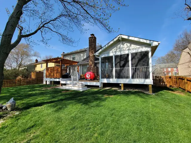 Backyard with a new four-seasons porch, a raised deck and a cedar pergola built by Five Fold Solutions